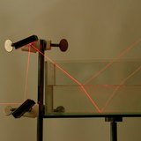 การหักเหและการสะท้อนแสงของแสงเลเซอร์ที่ขอบเขตของอากาศและน้ำ รวมถึงน้ำและแก้ว