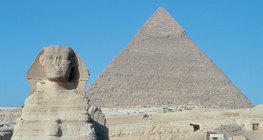 สฟิงซ์ (อียิปต์ ค.ศ. 2,500 ก่อนคริสตกาล) โดยมีพีระมิดคาเฟรอยู่เบื้องหลัง